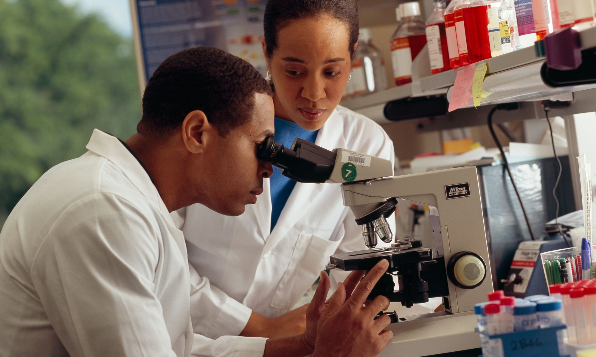 image of Researcher looking through microscope